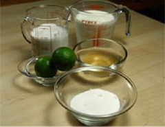 Ngâm lá gelatin vào nước lạnh. Đổ kem tươi và đường vào một tô khác. Bào vỏ 2 quả chanh rồi vắt lấy nước cốt 2 quả chanh đó, để riêng.