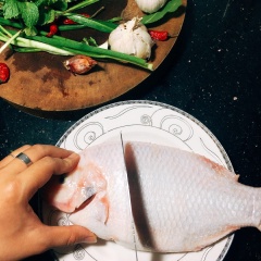 Làm sạch cá và rau. Khứa nhẹ cá để cho gia vị dễ thấm sâu hơn.