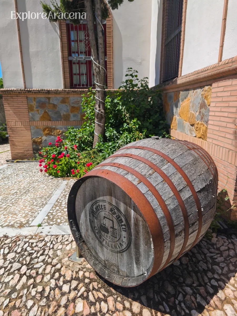 Wooden barrel with the Martes Santos branding displayed outside the entrance to the historic distillery near Aracena.