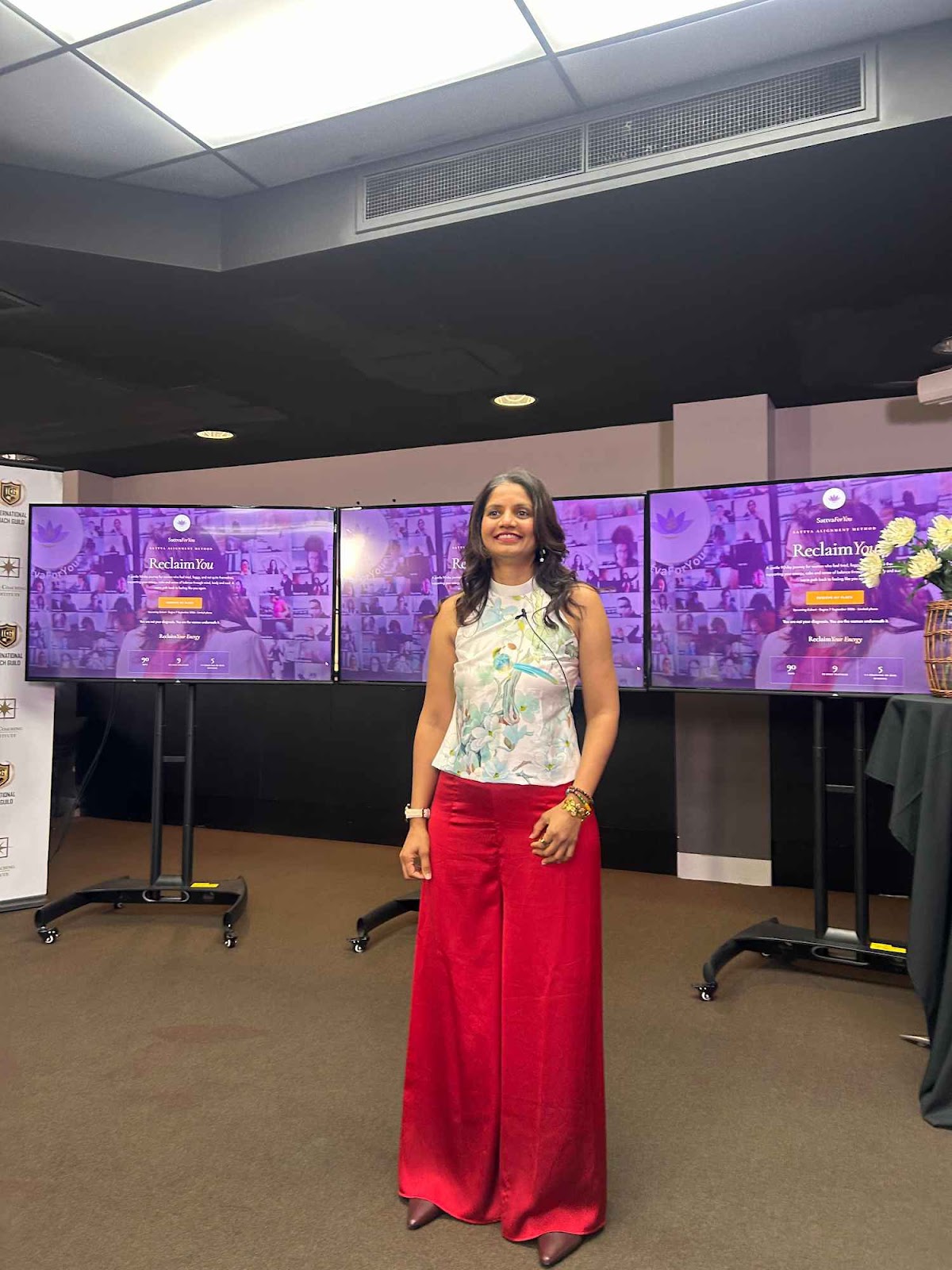 Preethi B Bellarry speaking passionately on stage, guiding women on a holistic journey to reclaim their energy and vitality