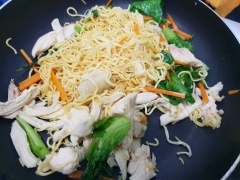 Chảo nóng, cho mì đã luộc vào xào tơi rồi thêm gà, rau củ quả xào đảo đều. Thêm sốt nước mắm tùy khẩu vị và đảo đều cho thấm vị là có thể tắt bếp rồi nha.