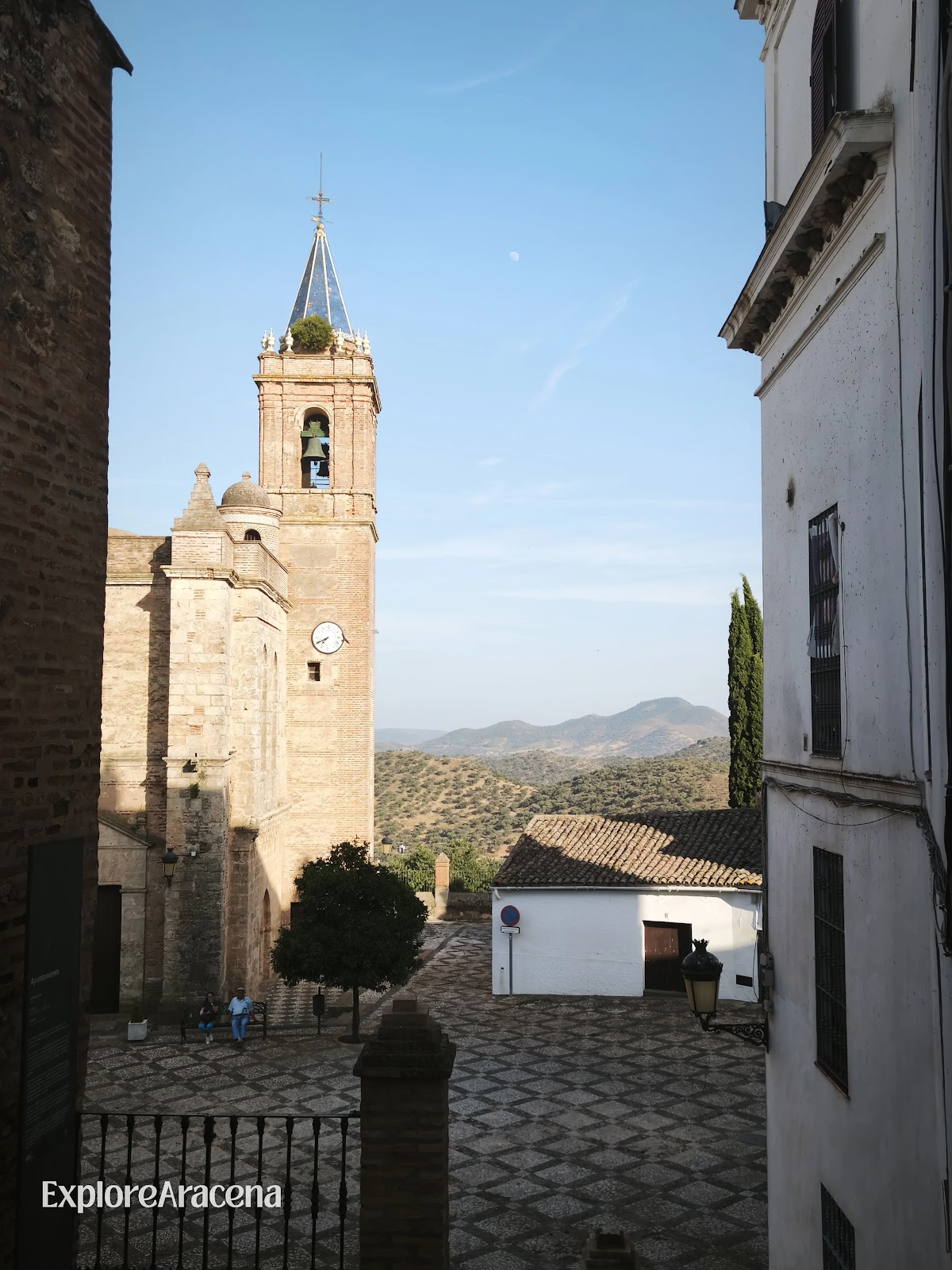 Church of the Purísima Concepción in Zufre’s Plaza de la Iglesia, with distant hills visible beyond the square.