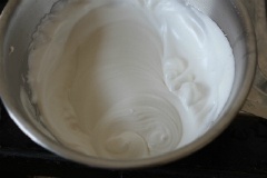 Cho phần 50gr bột mì vào hỗn hợp bơ, trứng, dùng phới lồng trộn đều. Lòng trắng, 70gr đường, 1/4 muỗng cà phê nước cốt chanh cho vào tô đánh bông trắng.