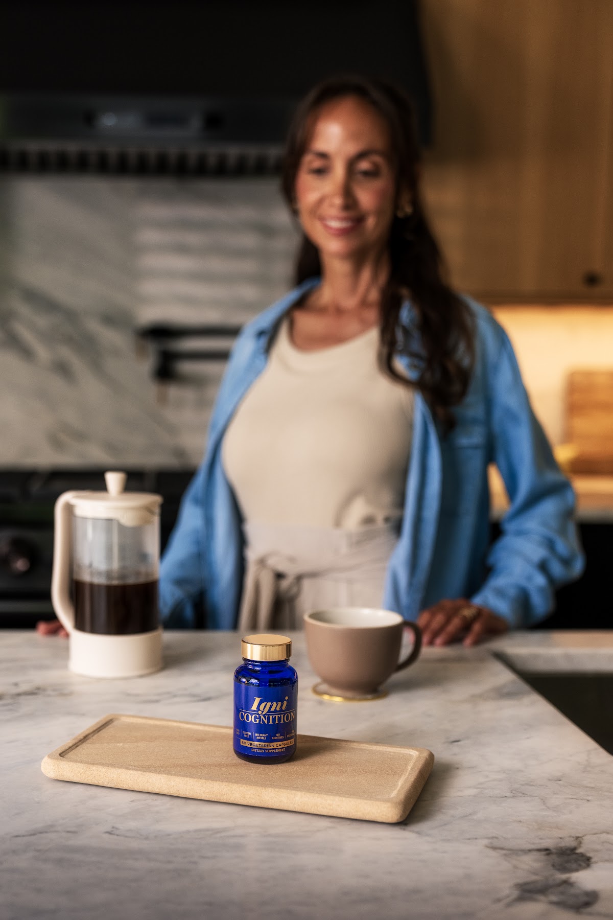 Woman in kitchen with french press and IgniCognition on the counter