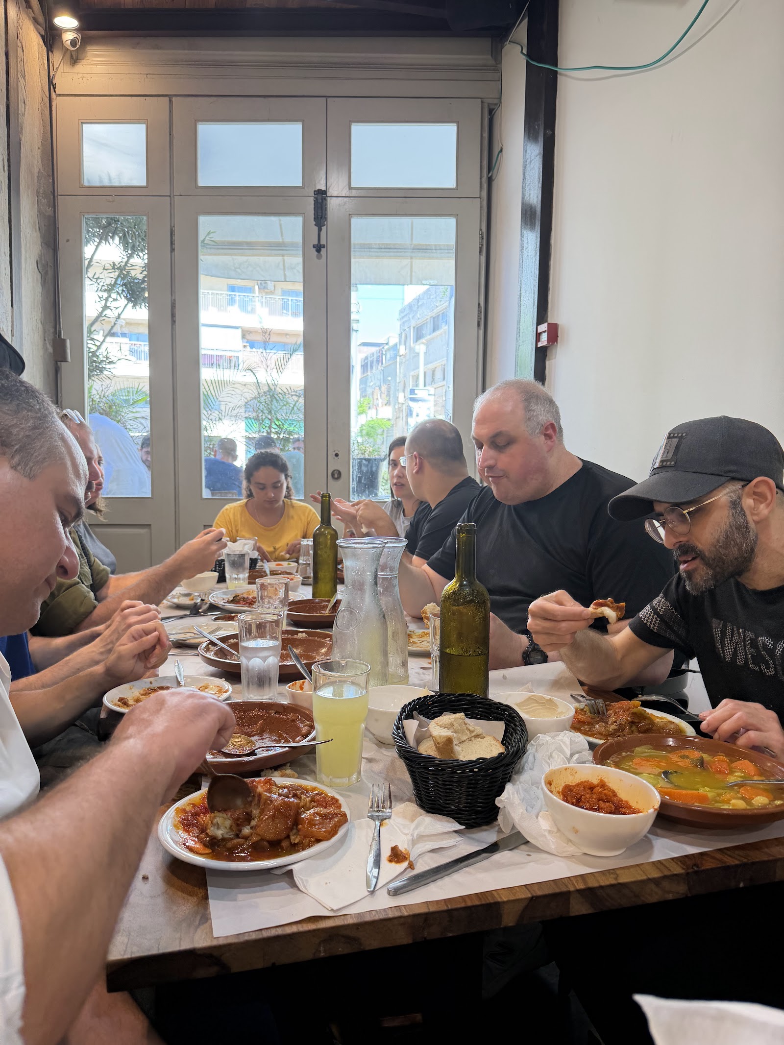 שולחן עמוס תבשילים טריפוליטאיים, לחם ולימונדה במסעדת גואטה