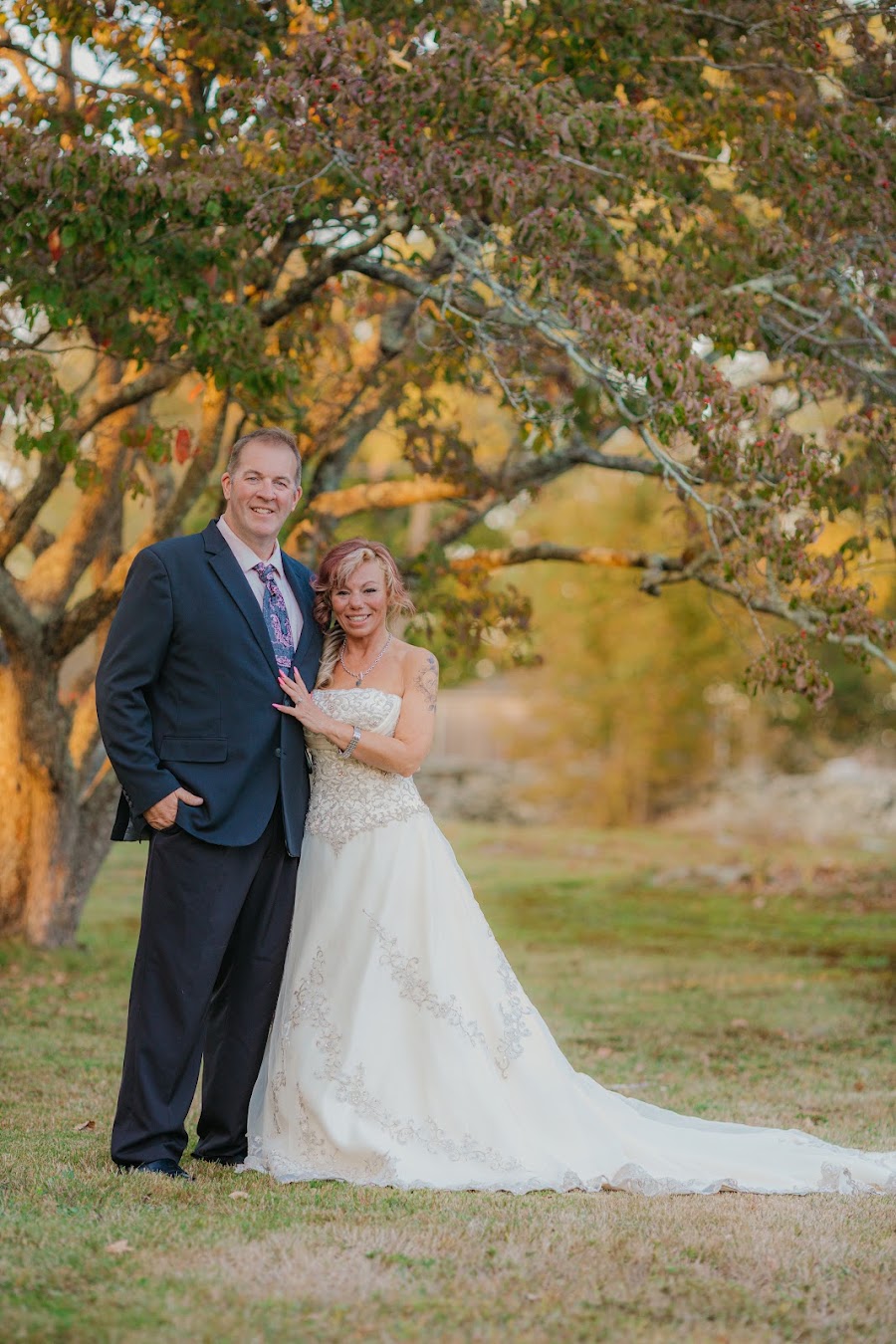 Bride and groom in warm field light at sunset