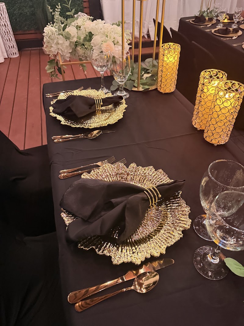 Gold charger with black napkin and candlelight place setting