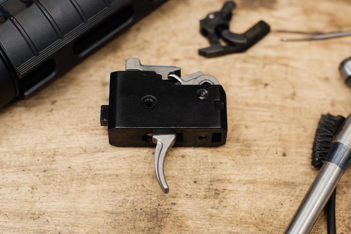 Shooter's finger seated on a polished single-stage trigger shoe during a rapid-fire drill