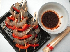 Tôm bóc vỏ, bỏ chỉ đen, giữ lại phần đuôi cho đẹp. Ớt chuông bỏ hạt, thái miếng 2x3cm. Xiên sen kẻ ớt chuông cùng tôm cho đầy que xiên. Trong chén nhỏ trộn, đều 30ml rượu, 30ml dầu ô liu, 1 muỗng cà phê bột cà ri, 1 muỗng cà phê ớt bột và 1 muỗng cà phê tiêu trộn đều. Ướp que xiên tôm và ớt với hỗn hợp nước ướp khoảng 5 phút.