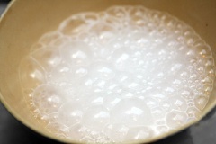 Cách làm bánh tiêu đơn giản: Hòa tan 50g đường vào 1/2 chén nước ấm. Khi đường tan hết thì cho 5g men nở vào và khuấy đều cho đến khi men nổi lên trên mặt nước như gạch cua là được.