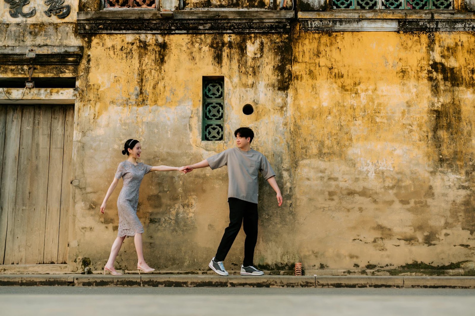 A couple laughing and walking hand-in-hand in a city at sunset, representing authentic connection beyond AI dating apps.