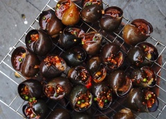 Cách làm ốc bươu nướng tiêu xanh: Chuẩn bị một bếp than, đặt ốc đã sơ chế lên vỉ nướng. Chờ cho ốc bốc hơi nóng thì lần lượt chang nước sốt tiêu xanh vào miệng ốc. Cho đến khi nước sốt trong ốc sôi lên và cạn bớt nước, sốt trong ốc keo lại, có mùi thơm nồng của tiêu xanh là được.