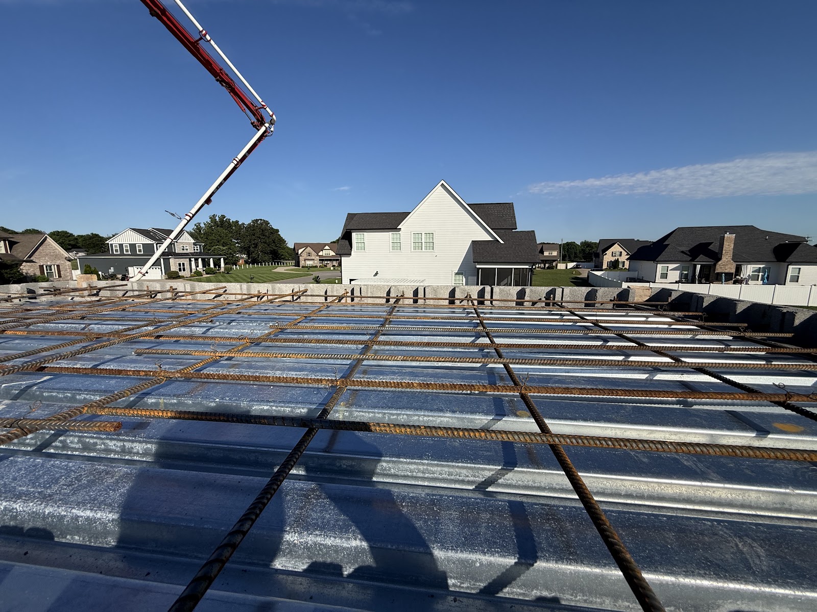 A grid of rebar laid over corrugated metal decking on top of a concrete block storm shelter structure.