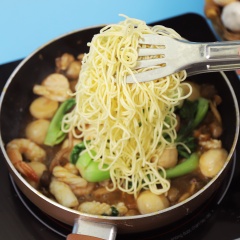 Sau đó, cho cải thìa vào xào 1 phút, cuối cùng cho mì, hành lá vào đảo đều cho thấm gia vị, đảo thêm 2 phút rồi tắt bếp.