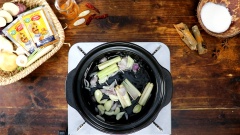 Bắc nồi lên bếp, cho vào 2 muỗng canh dầu ăn, đợi dầu nóng thì thêm vào 30gr sả cắt khúc đập dập, 20gr tỏi tép đập dập, 20gr hành tím thái lát, phi thơm các nguyên liệu. Tiếp theo cho thịt dê đã ướp vào xào sơ, sau đó thêm 500ml nước dừa vào nồi. Để lửa nhỏ hầm cà ri dê 20 phút.