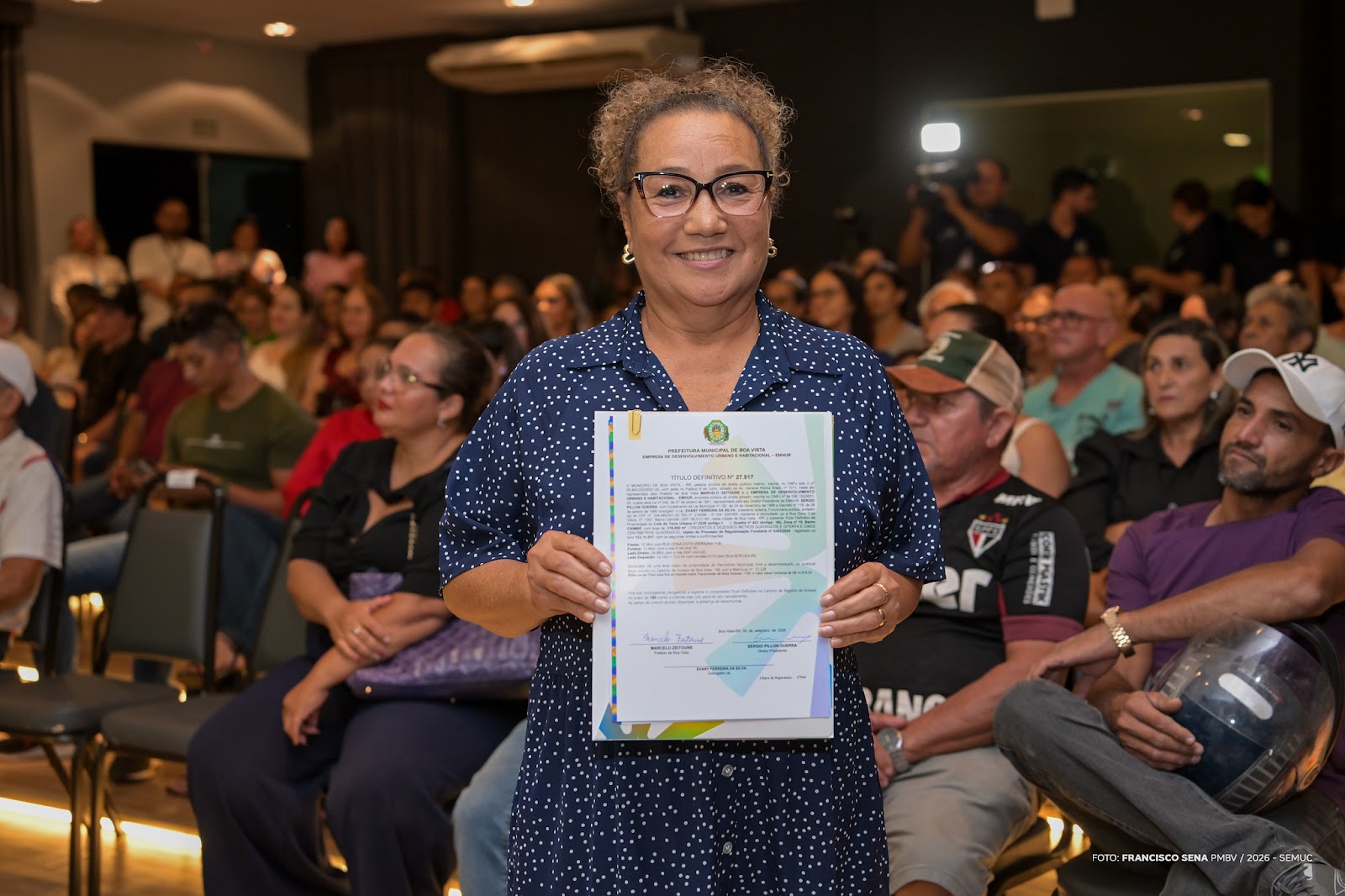 Auditório do Palácio 9 de Julho com moradores recebendo escrituras de imóveis em regularização fundiária em Boa Vista.