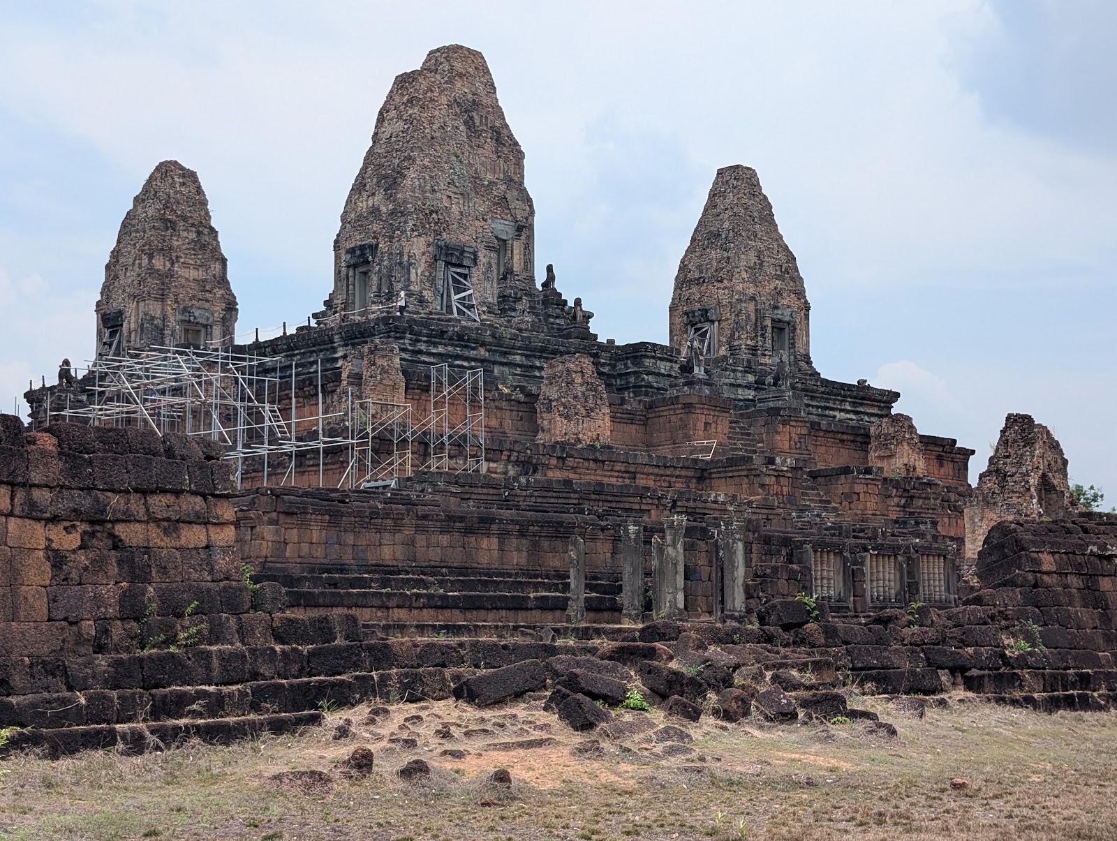 Temple ruins built from dark red and brown stones. Some
                 scaffolding is present on one side of the temple where some
                 restoration work is in progress