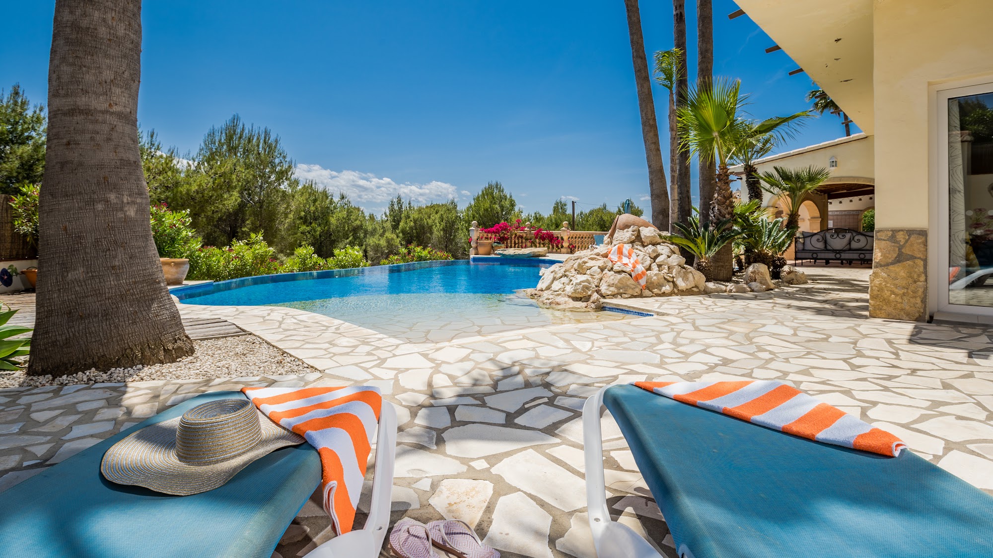 Private pool with palm trees in full sunshine
