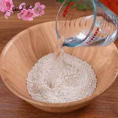Cho 1kg gạp nếp cái vào âu lớn, đổ nước vô ngâm gạo khoảng 2 tiếng rồi vo sạch, chia gạo thành 2 phần bằng nhau.