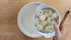 Đun 1 lít nước, cho đường phèn vào khuấy tan, để nguội, cho vải bỏ hạt vào ngâm. Hạnh nhân rang vừa vàng thơm.