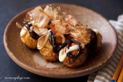 Xếp bánh ra đĩa, rắc chút cá bào và rong biển vụn, rưới nước sốt teriyaki và mayonnaise. Dùng nóng (để nguội bánh sẽ hơi xẹp và kém xốp hơn một chút). Mời cả nhà cùng măm