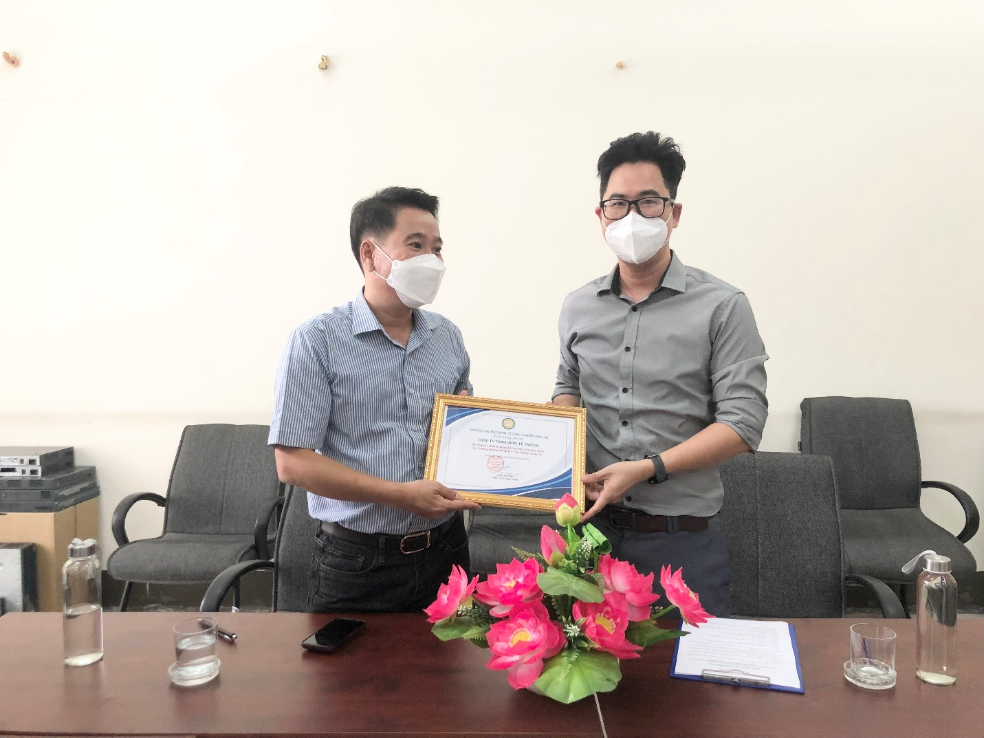 Giám đốc công ty (bên trái) nhận thư cảm ơn từ Nhà trường vì sự hợp tác, đồng hành cùng sinh viên và đã trao tặng Nhà trường một số thiết bị tin học tại buổi ký kết biên bản ghi nhớ hợp tác.