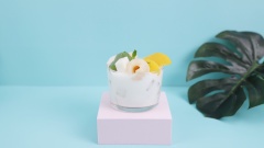 Thành phẩm: Cho vào tô đá nhuyễn, thêm 300ml sữa chua uống Đà Lạt Milk vào, sau đó thêm topping vải ngâm, đào ngâm, thạch sữa chua lá dứa rồi thưởng thức.