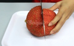 Gấc cắt làm đôi, dùng muỗng múc lấy phần cơm gấc, cho ra tô.
