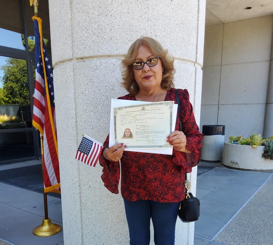 Cliente mostrando su certificado y una bandera estadounidense