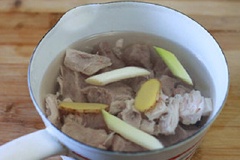 Cho vào nồi thịt bò, 1/2 chỗ đầu hành lá, 2 lát gừng, 1 muỗng canh rượu trắng, 300ml nước lọc đun lửa nhỏ trong khoảng 15 phút. Khi thịt chín vớt ra, rửa qua nước lạnh.