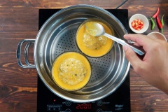 Nhanh tay, tách 2 lòng đỏ trứng vịt, đánh đều lên. Cho lên mặt chén mắm, dùng muỗng dàn trãi đều trứng trên mặt chén. Đặt 1 lòng đỏ trứng muối giữ chén. Xếp ít ớt xung quanh cho đẹp. Tiếp tục đậy nắp hấp thêm 10 phút nữa.