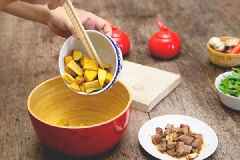 Lần lượt cho vào tô: khoai lang, bí đỏ chiên, dưa leo, thịt bò và lá húng quế. Cho tiếp sốt vừa pha vào, trộn đều lên.
