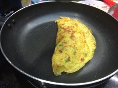 Khi bánh chín vàng một mặt, dùng xẻng gấp bánh làm đôi, chờ thêm 2-3 phút cho bánh chín hẳn, vớt ra đĩa ngay. Làm lần lượt cho đến khi hết bột.