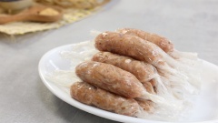 Tiếp đến là bước gói nem, cắt màng bọc thực phẩm thành những miếng vuông, làm tới đâu cắt tới đó. Trải miếng nilon lên thớt cho dễ gói. Cho khoảng 2 muỗng canh hỗn hợp thịt và bì đặt ở giữa miếng nilon, cuốn tròn lại, ở hai đầu nilon xoắn lại như vặn kẹo sao cho thịt nem thành hình ống dài là được. Gói nem xong ta cho nem chua vào tủ lạnh khoảng 2 tiếng cho nem lạnh và được định hình.