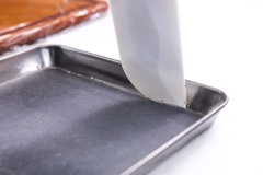 Áo một lớp dần mè lên khuôn rồi đổ hỗn hợp mè đen vào dày khoảng 0.3 cm. Hấp hỗn hợp mè đen ở nhiệt độ cao trong 3 phút và dùng thìa (spatula) để lấy bánh cho ra một bên.