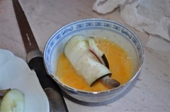 Rải bột chiên giòn ra đĩa. Đánh trứng tan đều, nhúng cuốn cà tím vào trứng. Sau đó lăn qua đĩa bột chiên giòn.