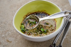 Cho 3 muỗng canh nước tương, 2 muỗng canh giấm, 1 muỗng canh đường, mè trắng và hành lá nhỏ vào chén. Trộn đều làm nước chấm.