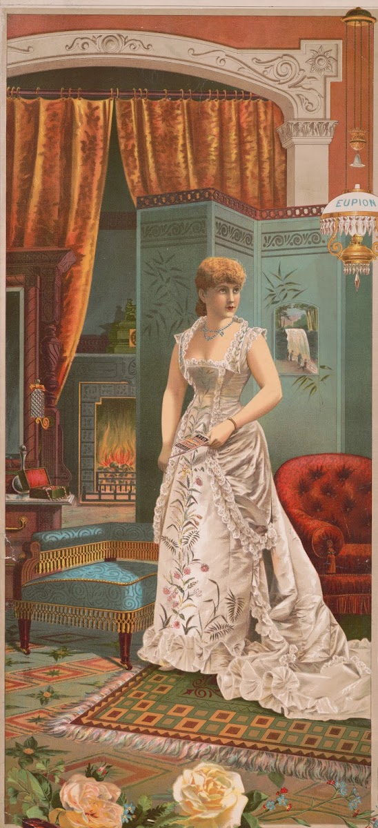 Woman In White Dress Standing Holding A Eupion Oil Brochure With Fireplace And O