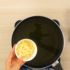 Bắc chảo lên bếp cho dầu ăn vào đợi sôi, cho tiếp 2 muỗng canh tỏi băm vào phi thơm. Vớt tỏi phi ra dĩa có lót giấy thấm dầu.
