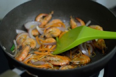 Trong chảo khác, xào thơm gừng, hành lá với 2-3 muỗng canh dầu ăn, cho hành tây và cà rốt xào, xào 1-2 phút. Sau đó đổ tôm đã chiên trở lại xào cùng. Nêm 1 muỗng canh nước tương, ít tiêu, xào tiếp 2-3 phút thì tắt bếp.