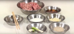 Giã nhỏ tỏi với hành lá, cho thịt vào cối giã, nêm nếm cùng nước mắm, đường, tiêu và giã nhỏ tất cả các nguyên liệu.
