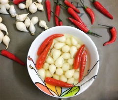 Tỏi ngâm giấm ớt trắng giòn là một trong những món ăn truyền thống trong dịp Tết của nhiều người. Không tốn nhiều thời gian để bạn có thể hoàn tất vài hũ tỏi ngâm chờ dùng trong những bữa cơm đầu năm rồi nhé!