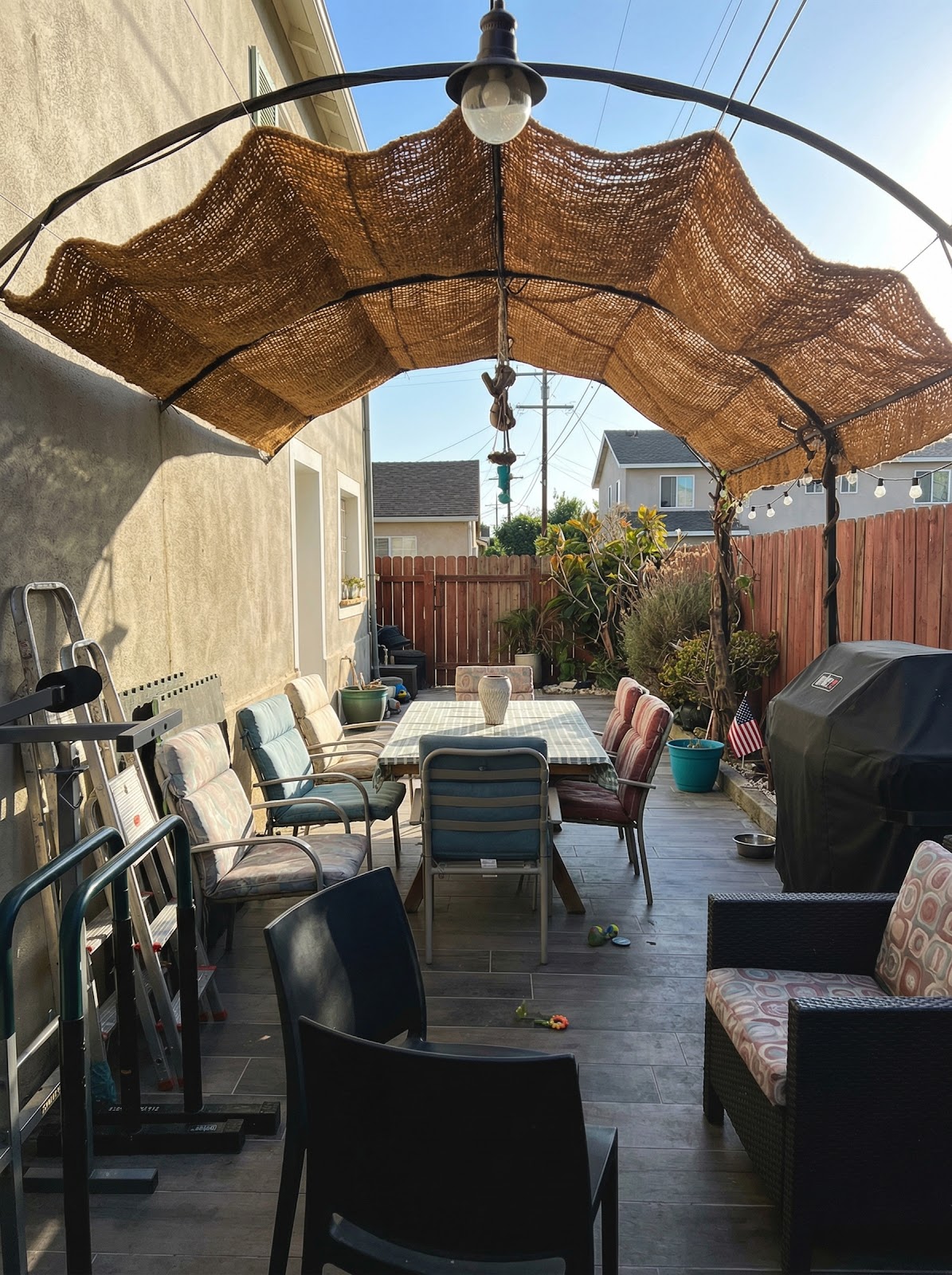 Arched patio shade structure with coir canopy and string lights