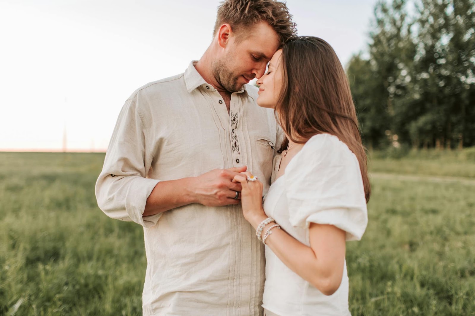 A genuine human couple holding hands at sunset, representing authentic connection beyond AI-powered dating apps.
