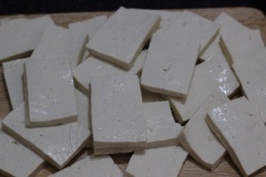 Nấm hương ngâm nở mềm rửa sạch, cắt nhỏ. Đậu hũ cắt lát mòng dày 6 - 7cm. Cho thịt heo bằm, nấm hương, trứng gà, 1 muỗng bột bắp, tiêu, hạt nêm vào tô và trộn thật đều. Một miếng đậu hũ khi hấp sẽ có 3 lớp đậu 2 lớp thịt. Lần lượt xếp 1 lớp thịt lên đậu hũ rồi lên một lớp đậu hũ, làm như vậy đến khi hết nguyên liệu nhé.