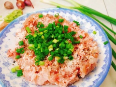 Hành lá rửa sạch, thái nhuyễn. Cho thịt heo xay ra dĩa, cho hành lá, ½ muỗng cà phê muối, 2 muỗng canh nước mắm, 1 muỗng cà phê hạt nêm, 1 muỗng cà phê bột ngọt, 1/4 muỗng cà phê đường, 1 muỗng cà phê tiêu vào thịt. Trộn đều cho thịt thấm gia vị. Mỡ heo rửa sạch, sau đó thái hạt lượu nhỏ. Rồi cho vào thịt heo vừa ướp rồi trộn thật đều. Mỡ heo sẽ giúp tăng độ béo và giúp miếng chả không bị khô. Cốm lựa bỏ hạt sâu, hạt lép. Sau đó mang cốm đi rửa sạch rồi vớt ra rổ để ráo.