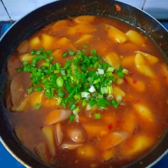 Khoảng 2 phút sau cho xúc xích vào, tiếp theo cho hỗn hợp bột năng đã khuấy với nước vào để sốt đặc lại. Rắc hành lá và tắt bếp.