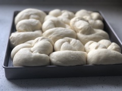 Làm nóng lò trước 10 phút, nhiệt độ 180 độ, cho khay bánh đã lót giấy nướng vào lò, bánh mì đã nở gấp 2 lần, mang đi nướng 25 phút. Phết bơ lên mặt bánh sau khi nướng, giúp mặt bánh bóng và thơm mùi bơ.