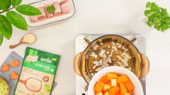Tiếp đến cho nồi lên bếp, đun nóng 2 muỗng canh dầu ăn, thêm 15gr hành tây vào xào thơm rồi cho khoai tây và cà rốt vào đảo cùng. Cho 350ml nước vào nồi khuấy nhẹ, đun sôi 15-20 phút. Sau đó tắt lửa, cho hỗn hợp vào máy xay nhuyễn mịn. Trút hỗn hợp xay nhuyễn trở lại nồi đun sôi.