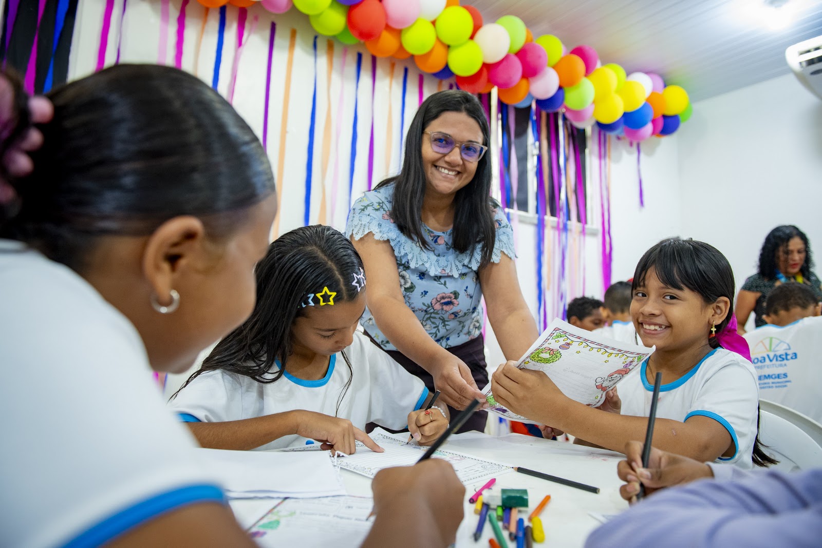 Educadora social acompanha crianças na escrita de cartinhas do Papai Noel dos Correios em Roraima